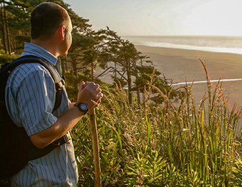 Man stops to enjoy the scenery while hiking at Seabrook